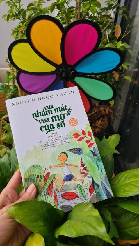 [Vừa nhắm mắt vừa mở cửa sổ]
Lát cắt cuộc sống của một đứa trẻ 10 tuổi về gia đình, bạn bè, hàng xóm láng giềng và một đứa trẻ lang thang khác sống trong chợ. Vừa nhắm mắt vừa mở cửa sổ là hành động thường xuyên lặp lại của cậu bé khi dang tay đón lấy hương thơm và không khí trong lành từ vườn hoa nhà mình. Không nhìn bằng mắt nữa, chuyển sang "nhìn" bằng các giác quan khác, bạn sẽ cảm nhận được sự thú vị của cuộc sống. Chạm tay vào cánh hoa, hít hà hương thơm cỏ cây, lắng tai nghe tiếng xao động của từng kẽ lá, trái tim bình yên đến lạ.
Cách kể chuyện mộc mạc, bình dị, hồn nhiên pha chút hài hước cuốn người đọc vào từng mảnh ghép cuộc sống của cậu bé lúc nào không hay.
#vuanhammatvuamocuaso