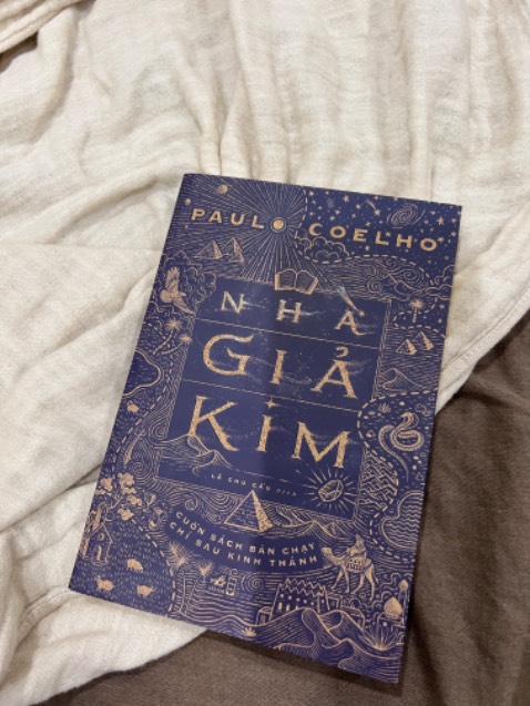 • Về hình thức.
Bìa bắt mắt với ảo ảnh hạt cát nhoè bay, kiểu cuốn hút, huyền bí về Ai Cập.
Có 1 vài trang in màu giới thiệu về nhân vật khá xinh xắn.
Giấy dày đẹp, chất lượng tốt.
• Về nội dung.
Vì biết nó là cuốn sách nổi tiếng và bán chạy nên mình mong chờ nhất trong 10 cuốn sách mình đặt cùng lúc đó.
Tuy nhiên nó đã làm mình thất vọng về nội dung! Phần đầu cũng khá là cuốn theo mạch sách, mong chờ lúc nhân vật chính sang Ai Cập sẽ có nhiều những câu chuyện thú vị hơn, những triết lý sâu sắc hơn. Nhưng mà đọc tới phần sau nó hơi ...gãy. Thực sự những câu chuyện k có j thú vị và ấn tượng. 
Xoay quanh về đức tin đấng trên cao, có niềm tin mãnh liệt và theo đuổi ước mơ của mình tới cùng, lắng nghe trái tim, đi tìm kho báu của cuộc đời mình, sống thiện lành và tích cực..v.v...với những chủ đề đẹp đẽ này nhưng khi vào sách nó bị lặp đi lặp lại câu chữ, câu chuyện thì sơ sài...
Về nội dung chấm 4/10