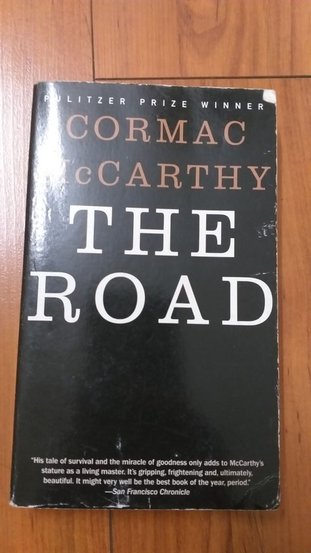 Review sau 1 tháng ngồi đọc của mình:
- Về hình thức: Bìa mềm, mỏng nên dễ bị nhàu, cũng không có điểm gì nổi bật về thiết kế bìa nhưg nếu xét đến chủ đề của sách thì mình thấy phong cách tối giản này là phù hợp; giấy cũng mỏng nên nếu dùng bút highlight để note sẽ bị; sách khổ nhỏ mass market nên giá rẻ và cầm đọc ở nơi công cộng là vừa tiện (nhưng theo mình thì đây là cuốn sách chỉ nên đọc ở nhà trong yên tĩnh là hợp lý nhất)

- Về nội dung: đây là một câu chuyện rất nặng nề và dữ dội nhưng cũng cảm động vô cùng. Một câu chuyện về tình cha con đầm ấm, cả hai phải dựa vào nhau để cùng vượt lên những khó khăn của hoàn cảnh sống khắc nghiệt trong một thế giới hậu tận thế. Mặc dù nội dung khá tăm tối với những cảnh vật ảm đạm luôn chìm trong khói lửa và sự tàn bạo của con người trong sự bần cùng, nhưng tác giả Cormac vẫn điểm vào đó những điểm sáng của cuộc sống giản dị của hai cha con như muốn nhen nhói hi vọng cho những nhân vật cũng như cho người đọc. Một quyển sách rất đáng đọc, xứng đáng với các lời phê bình.

Nhiều câu văn vô cùng cảm động mà khi mình đọc vẫn cảm thấy chạnh lòng vì cách dùng từ của nhà văn vô cùng uyển chuyển. Cormac cũng là một bậc thầy của mô tả cảnh trí và thiên nhiên nên khi đọc bạn có thể hình dung rất chi tiết khung cảnh mà nhân vật của ông đang trải qua. Nhiều câu liên quan tới vấn đề nhân sinh hay tôn giáo cũng khá phức tạp và đa nghĩa (cái này mình phải tham khảo trên mạng mới hiểu hết đc) mà mình nghĩ sẽ khiến nhiều người khó hiểu và hập hững khi không hiểu được hết ý. Một số từ viết thu gọn (vd don't, can't) sẽ không có dấu nháy (theo mình thì tác giả có ý đồ trong việc này). Lượng từ mới cũng là khá nhiều. Về tổng quát thì mình có thể nói thì đây là một quyển sách tương đối khá đọc. Bạn nào mới bắt đầu học tiếng anh thì nên cân nhắc trc khi đọc nhá