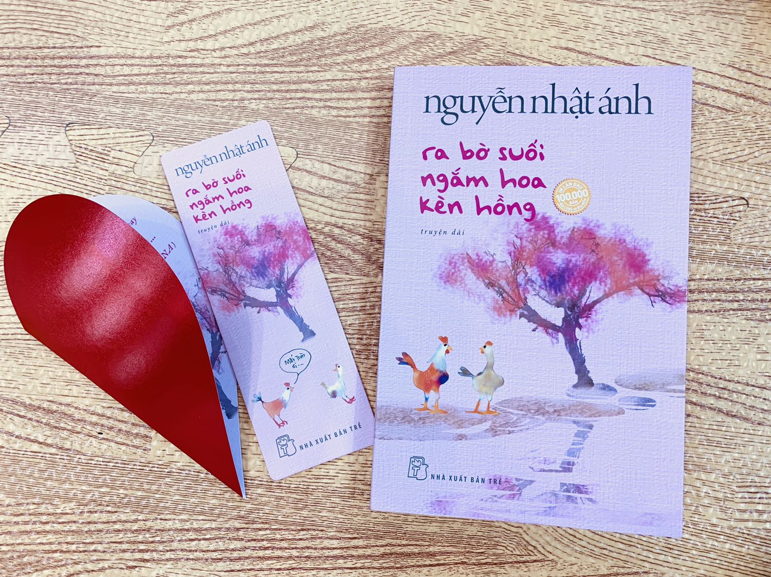 Mình mua từ trc Tết, Tiki hẹn giao 8/2 dương mà hên quá ngày 27 âm đã giao.
Mùi sách thơm phức, cuốn sách tuyệt đẹp, bookmark xịn xò và quan trọng hơn cả là câu chuyện nhân văn vô cùng của bác Ánh.
Ngòi bút viết về nỗi buồn đang tìm đến đào hang và làm tổ trong lòng cô gà con, về nỗi đau để lại vết xước trong lòng cô, về bông hoa đang nở rộ trong lòng .... bút lực và ngôn ngữ của bác Ánh mới tuyệt vời làm sao.
Vừa đọc vừa trầm trồ về những từ ngữ đắt giá, về khả năng diễn tả tâm lý, hay khả năng định nghĩ lại vài từ (như 'đời tư' hay nhiều từ khác).
Và hơn cả là mạch truyện làm người ta ồ lên ở phút cuối.
Hoá ra, ra bờ suối ngắm cây kèn hồng không phải hẳn là ngắm cây kèn hồng.
Hoá ra dưới cây kèn hồng không chỉ là câu chuyện của hai con gà đã kịp lớn tương đương nhau.
Dưới cây kèn hồng, bên bờ suối, còn là 'kỷ niệm'.
Cảm ơn bác Ánh rất nhiều.