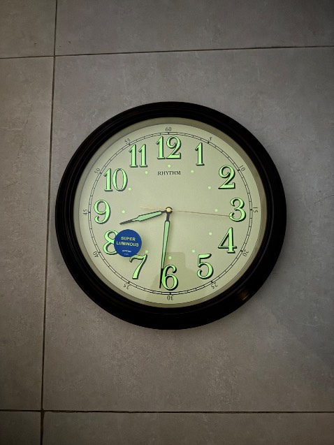 Đồng hồ treo tường thương hiệu Rhythm với thiết kế cổ điển.

	1.	Mặt số rõ ràng, dễ nhìn: Các con số được in lớn, giúp dễ dàng quan sát từ xa.
	2.	Dạ quang trên số và kim: Đồng hồ có chức năng phát sáng trong bóng tối, giúp người dùng nhìn giờ dễ dàng vào ban đêm.