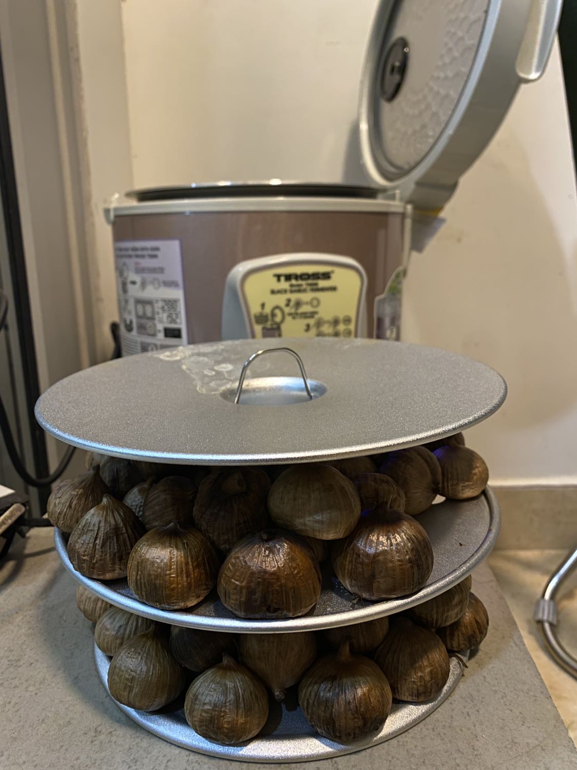 Đã dùng làm 2 mẻ tỏi đen, đang làm mẻ thứ 3. Xếp khéo thành 2 lớp ở mỗi tầng sẽ được 1.5kg cho mỗi lần làm. Mình chọn tỏi cô đơn loại lớn nên sau 12 ngày ra đc tỏi nâu còn nhiều nước, dùng thêm chức năng sấy 2h thì tỏi vẫn mầu nâu và nước còn nhiều.
Sau khi thử nhiều lần thì mình có thêm công thức phụ là dùng lò chiên ko dầu chỉnh nhiệt độ 100 độ, sấy thêm 2h thì tỏi đẹp ngon.