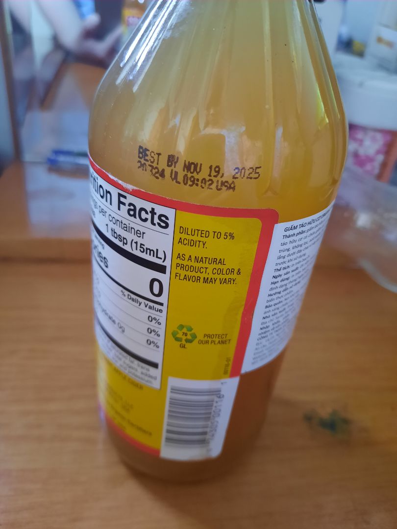 Mình mua 2 chai giấm táo Bragg này thấy dán nhãn tem của NNK & PP Vũ An. Màu giấm rất nhạt so với giấn táo mình mua trước đây, dưới đáy chai cũng trong veo không thấy cặn đóng màng như chai cũ. 
Nét mực in date và mã code cũng thô, không tinh tế, mảnh như những chai cũ (rất tiếc mình đã bỏ vỏ chai cũ nên không có hình ảnh đối chiếu). Đặc biệt là, mã bưu cục trên nhãn chai để địa chỉ là CA 93101 USA nhưng trên nhãn tem của NNK Vũ An lại đề là CA 93102 USA. 
Mình muốn shop có câu trả lời thích đáng để mình yên tâm không mua lầm phải hàng giả hàng nhái. Xin cảm ơn