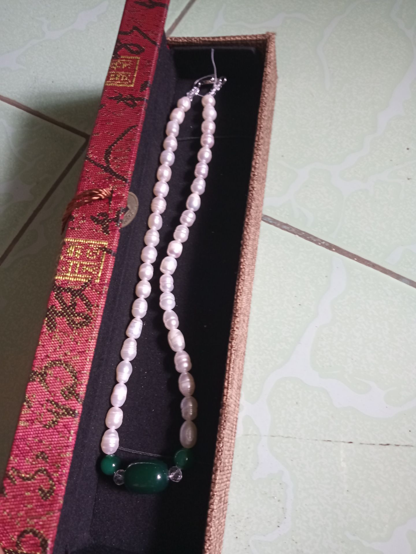 như quảng cáo , viên chuỗi không đều , " mềm " , nhìn gần không đẹp mắt - có viên trong , viên đục , có vài viên bị " tổn thương" . Tuy nhiên khi đưa lên ánh sáng , hơi lấp lánh , màu sắc thay đổi chút ít ở độ sáng và góc nhìn khác nhau