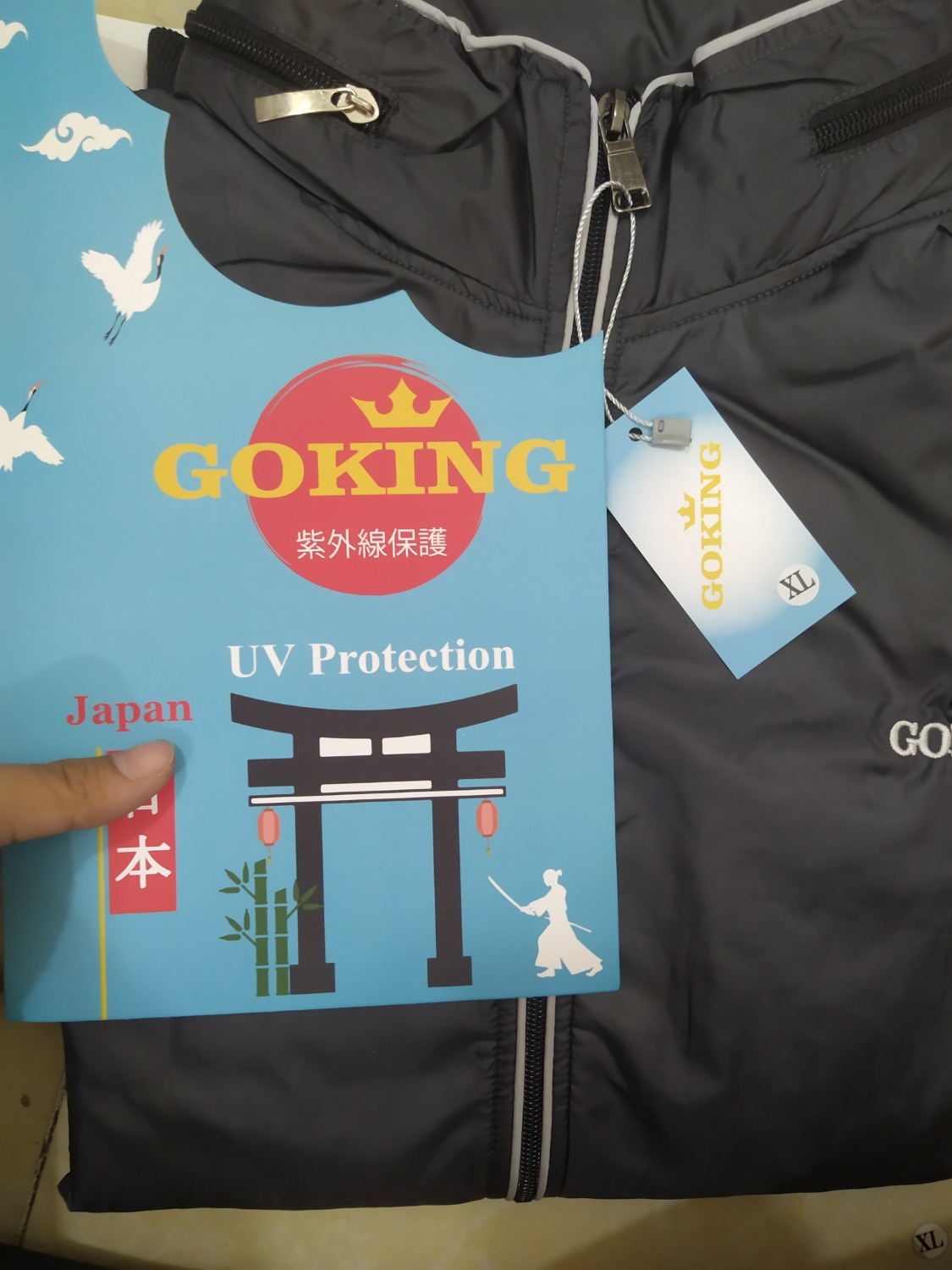 Áo này có cái mũ nè,  thấy có cái khóa kéo nhỏ trên cổ mở ra thấy có một cái mũ được gấp vào, áo đẹp, mặc dù vải dù nhưng mà bên trong có vải lót, vải có lỗ thông hơi nên cũng không nóng quá khi đi nắng