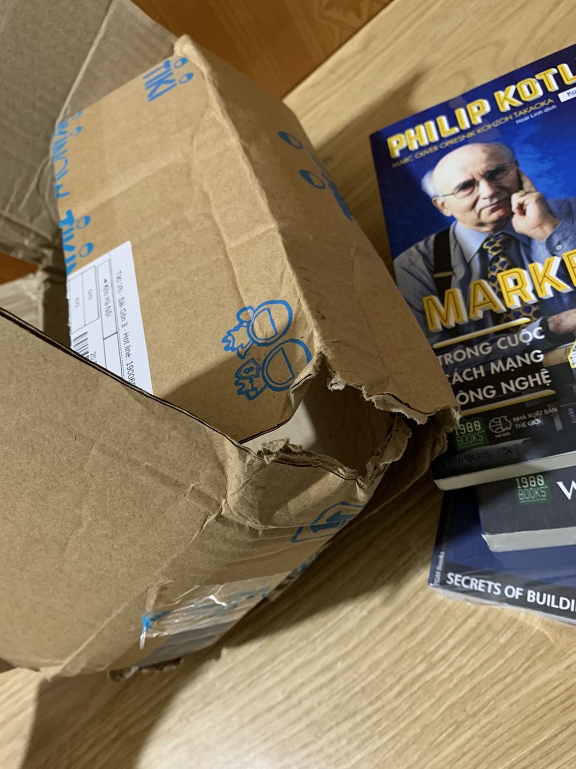 Cuốn này mua không được bọc nilong bên ngoài, góc hơi coăn nhưng không đáng kể, tạm chấp nhận nhưng mặt sách có lỗi. Thùng bên ngoài còn bị rách, thôi cái thùng thì mình cũng cho qua vì có thể do bên vận chuyển. Thực sự chưa lần nào mình nhận được mấy cuốn sách mua mới mà giống như sách cũ, rất bụi như kiểu để lâu trên kệ mà không còn giấy bóng bọc bên ngoài như này.