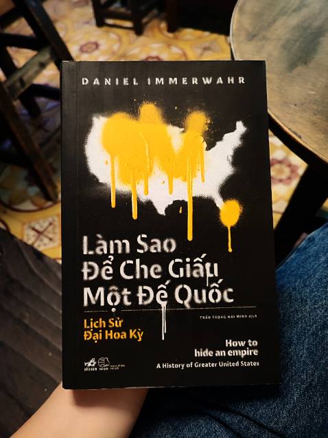 LÀM SAO ĐỂ CHE DẤU MỘT ĐẾ QUỐC - MỘT GÓC NHÌN PHẢN BIỆN LỊCH SỬ HẤP DẪN
Đã có hàng nghìn cuốn sách viết về lịch sử Hoa Kỳ, đề tài tưởng chừng như đã bão hòa như cát trong sa mạc. Ấy vậy mà cuốn sách Làm Sao Để Che Dấu Một Đế Quốc, xuất bản năm 2019, lại gây được tiếng vang lớn, lọt vào danh sách Sách hay nhất do nhiều tờ báo uy tín bầu chọn và nhận được những giải thưởng lớn. Có gì thú vị và khác hơn trong đó?
Cuốn sách bắt đầu bằng một góc nhìn phản biện về cách mà Hoa Kỳ muốn được hình dung kể từ thời điểm lập quốc cho đến thời hiện đại. Bằng những biện pháp khéo léo một cách vụng về, giới tinh hoa của Mỹ đã luôn che dấu tính chất đế quốc và "xa lánh" những người dân sống ở các vùng thuộc địa mà đáng ra họ cũng chính là những người dân Mỹ.
"Mọi người sinh ra đều bình đẳng, rằng tạo hóa đã ban cho họ những quyền tất yếu và bất khả xâm phạm, trong đó có quyền sống, quyền được tự do và mưu cầu hạnh phúc", tuyên ngôn độc lập 1776 của Hoa Kỳ đã viết như thế. Tuy nhiên thực tế người Mỹ hiểu rõ hơn ai hết cách mà sự bình đẳng thực sự được "thực hiện". "Bình đẳng" hình như chỉ là khái niệm dành cho người da trắng. Những người Mỹ bản địa bị coi như đám man di mọi rợ và bị xua đuổi như thú dữ để rồi co cụm lại thành một nhúm đất nhỏ giam cầm họ như chuồng nuôi.
Cuối thế kỷ XIX, Hoa Kỳ đã có trong tay mình Haiwaii, Puerto Rico, Guam, Philiphines. Tuy vậy tư cách của người dân những khu vực này chưa bao giờ được nhìn nhận công bằng. Câu hỏi những khu vực này có phải là đất của Mỹ hay không, có phải là thuộc địa của Mỹ hay không luôn lấp lửng. Giới tinh hoa che đậy nó trong những toan tính về chính trị, quân sự.
Sự phủ nhận đó đã tạo nên những cuộc bạo động ở các vùng lãnh thổ, những cuộc binh biến và cả những thảm sát nhơ nhuốc chôn vùi hàng trăm nghìn thi thể dân thường trong hố sâu của sự vô cảm.
Câu chuyện của Philiphines năm 1896 cho thấy rõ điều đó. Thời điểm này, Philiphines đang là thuộc địa của Tây Ban Nha. Những người khởi nghĩa dưới sự dẫn dắt của Aginaldo đã đấu tranh bất khuất. Khi nước Mỹ dẫn quân đến Philiphines, chính Aginaldo coi họ như những đội quân đại diện cho nhân đạo đến để cứu chuộc đất nước ông khỏi áp bức. Ông đã làm hết mình đã hai lực lượng hỗ trợ nhau. Mỹ nhanh chóng gạt bỏ Tây Ban Nha ra khỏi Philiphines một cách dễ dàng. Trái với những hi vọng ban đầu, Aginaldo và người dân của mình thất thần khi biết về thỏa thuận "bán" lại Philiphines của Tây Ban Nha cho Mỹ với giá 20 triệu đô la.
Khi Phát xít Nhật chiếm được Philiphines vào thế chiến II. Mỹ đã ra một quyết định ném bom hầu hết các tòa nhà nghi ngờ có quân Nhật trú ngụ để "hạn chế tối đa thương vong" nhưng không phải cho tất cả. Dân thường Philiphines bị gạt khỏi những tính toán. Cuộc oanh tạc bằng bom nalpan đã đạt được mục đích. Nhưng đổi lại, chua xót là cứ 1 sinh mạng lính Mỹ mất đi thì có đến 100 sinh mạng khác của dân thường Manila cũng tan biến dưới làn bom mù trời.
Đó là cách Mỹ đã che dấu một cách vụng về bản chất "đế quốc" của mình.
Phần I của cuốn sách tập trung chính về giai đoạn đầu cho đến khi thế chiến II kết thúc. Giai đoạn này do hạn chế của công nghệ quân sự và sự phụ thuộc vào các nguồn nguyên liệu phụ vụ kinh tế chính quốc và chiến tranh nên tham vọng của Mỹ cũng như các nước lớn là muốn tăng cường nhiều "vùng đất thuộc địa". Bá chủ về địa lý sẽ làm một trong những sức mạnh để bá chủ thế giới. Đó là điều mà Mỹ đã làm nhưng không dứt khoát. Có một điều khác biệt giữa Mỹ và Anh (trước đó đã từng được mệnh danh là 'Đế quốc Mặt trời không bao giờ lặn'), người Anh tự hào về bản chất đế quốc của mình trong khi người Mỹ cố gắng che đậy và không thiếu những tranh luận liên tục về việc đi theo nó. Nhưng dù cách này hay cách khác, đế quốc vẫn là đế quốc.
Ở Phần II, tác giả phân tích về những thay đổi từ sau thế chiến II diễn ra trong địa hạt của khoa học - công nghệ, kéo theo sự thất thế của yếu tố địa chính trị. Một đế quốc ở giai đoạn mới không nhất thiết phải sở hữu nhiều lãnh thổ nữa. Nước Mỹ đã trở thành một đế quốc điểm họa (tức là chiếm đóng không phải là những vùng đất mà là những điểm nhỏ trên bản đồ). Công nghệ không vận, các vũ khí tối tân cùng những rắc rối mà việc cai quản một vùng đất thuộc địa mang đến đã khiến Mỹ lựa chọn điểm họa như một chiến lược mới hợp lý hơn. Nước Mỹ giai đoạn này đã tạo nên quyền lực của mình theo những cách thức phi biên giới và thường được gọi theo một khái niệm hoa mỹ "toàn cầu hóa".
Cuốn sách chứa đựng những góc nhìn mới về khái niệm Đại Hoa Kỳ mà lịch sử Mỹ đã cố gắng che đậy chính những người dân của mình. Một góc nhìn nhân văn của tác giả về những vùng đất trong đế quốc Hoa Kỳ. Bên cạnh đó là những phân tích hấp dẫn của tác giả về sự thay đổi của hình thức "đế quốc" mà Mỹ đang áp dụng. Cuốn sách này thực sự thú vị và có vô số chi tiết lịch sử hấp dẫn bạn. (Mình sẽ liệt kê ở phần cuốn bài viết). Giọng văn khi bi tráng khi trào phúng mà tác giả đã uyển chuyển thể hiện cũng khiến cuốn sách này thêm lôi cuốn bên cạnh cách kể chuyện đầy logic. Một điểm nữa không thể không nhắc đến ở ấn bản tiếng Việt là văn dịch khó có thể chê điểm nào. Nhã Nam chưa bao giờ gây thất vọng về dịch thuật cả.
Nếu bạn thích lịch sử, chính trị, đây có thể là một quyển sách nữa mà bạn không thể bỏ qua. 10/10 😃
....
Một số chi tiết thú vị trong cuốn sách mình lượm lặt lại:
1. Tấm bản đồ thế giới hình chữ nhật được cho rằng đã làm cho nước Mỹ chủ quan và hoàn toàn bất ngờ khi Nhật Bản tấn công Trâu Châu Cảng. Trên tấm bản đồ kiểu cũ đó, nước Mỹ ở phía rìa bên Trái còn Nhật Bản ở rìa bên phải. Tuy nhiên Nhật gần Mỹ hơn thế. Đã có những đề xuất để điều chỉnh lại bản đồ thế giới ở Mỹ. Một tấm bản đồ mà trung tâm là cực Bắc đã được phê duyệt. Sau này tấm bản đồ này được vẽ lại giản lược để làm thành logo của Liên Hiệp Quốc.
2. Mục đích ban đầu của Mỹ trong việc thôn tính của đảo trên Thái Bình Dương là để khai thác 1 loại phân chim dùng làm phân bón cho nông nghiệp (gọi là guano).
3. Puerto Rico là nguyên nhân của sự ra đời thuốc tránh thai. Nước Mỹ cho rằng dân số quá đông là nguyên nhân gây nên những thảm họa về kinh tế ở vùng lãnh thổ này. Họ đã phái những bác sĩ đến để nghiên cứu và thử nghiệm những biện pháp tránh thai, điều mà không được phép tại lục địa. Một trong những bác sĩ làm việc tại Puerto Rico nổi tiếng với bê bối sử dụng việc khám chữa bệnh để giết hàng chục người mỗi ngày, sau này ông này về nước và sau này được vinh danh như một trong những nhà nghiên cứu ung thu tận tâm nhất lịch sử Hoa Kỳ.
4. Cao su có vai trò vô cùng quan trọng trong quân sự. Giai đoạn Nhật xâm chiếm Đông Nam Á đã thể hiện điều đó. Sự thiếu hụt cao su nguyên liệu đã khiến cho chính quyền Mỹ vận động một cuộc quyên góp cao su cũ của toàn dân. Con chó cưng của Tổng thống đã quyên góp cục xương cao su của mình. Thậm chí một người trong chính quyền còn đề xuất giảm chiều dài của bao su xuống một nửa.
5. Tiêu chuẩn hóa là một trong những thành tựu vĩ đại mà Mỹ đã đóng góp cho thế giới công nghiệp hiện đại. Trước khi tiêu chuẩn hóa xuất hiện, đã xảy ra những vụ hỏa hoạn lớn mà lực lượng cứu hỏa khi đến nơi xảy ra vụ cháy kịp thời cũng đành phải bất lực đứng nhìn vì đầu ống cứu hỏa không tương thích với vòi cứu hỏa. Nước Mỹ đã tiêu chuẩn hóa từ ốc vít đến biển báo. Tuy nhiên hài hước là khi cả thế giới đều chấp thuận các đơn vị đo kiểu Pháp làm tiêu chuẩn chung (mét, km, gram) thì Mỹ vẫn bảo thủ sử dụng đơn vị đo của riêng mình. Điều này đã gây nên một số vụ tai nạn hàng không và vũ trụ do các nhân viên Mỹ tính nhầm đơn vị.
6. Tiếng Anh không phải phổ biến do sự đơn giản của nó. Một số nhà khoa học (ví như Einstein) phát hãi vì sự vô lối của tiếng Anh. Nhiều nỗ lực cải tổ tiếng Anh, đơn giản hóa tiếng Anh đã được thực hiện nhưng không đến đâu. Tiếng Anh được toàn cầu hóa đơn giản là do quyền lực của Mỹ. Một số ngôn ngữ nhân tạo ra đời (như Quốc tế ngữ) để làm đối trọng với tiếng Anh và loại bỏ đặc tính văn hóa ra khỏi ngôn ngữ, tuy nhiên đã thất bại.
7. Để "ngăn chặn" hành động tiếp theo của  Osama Bin Laden, Mỹ đã xây dựng một căn cứ giữa sa mạc Saudi. Đơn vị thi công mà chính quyền Saudi thuê là công ty của gia đình Bin Laden.

v.v.v...
Hiện tại thị phần đối với sách phi hư cấu (nonfiction) ở VN chưa thể so sánh được với các sách hư cấu (tiểu thuyết). Hi vọng có thể chia sẻ và khởi dậy đam mê sách phi hư cấu với các bạn để lĩnh vực này có thể được các nhà xuất bản để ý hơn, mang đến cơ hội tiếp cận với những cuốn sách hay hơn nữa. :D
