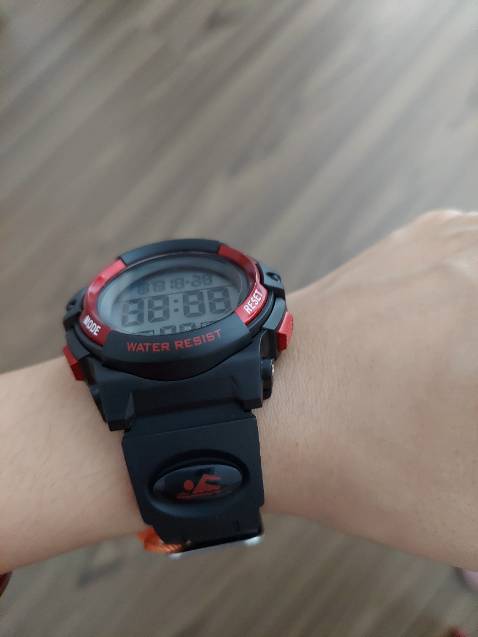 Đồng hồ khá to, có đèn để xem giờ trong bóng tối, quai nhựa hơi cứng. Cháu mình dùng cũng 2 tuần rồi chưa thấy vấn đề gì.